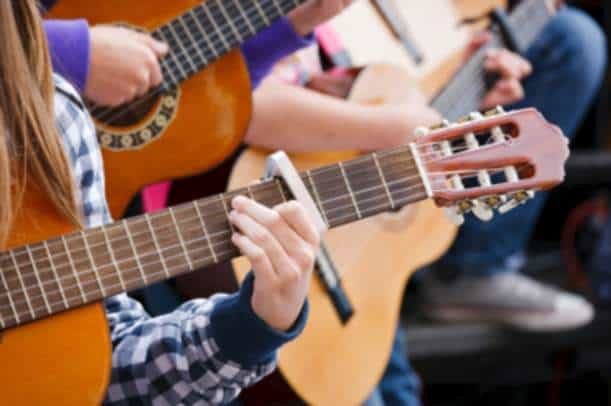 Children playing guitar in a group